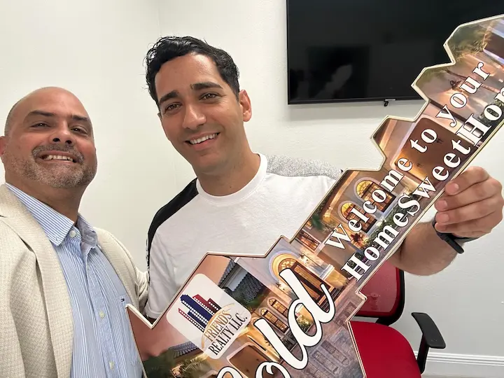 realtor image holding key with buyer