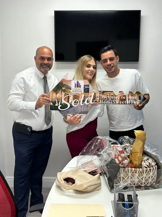 realtor with happy couple and key